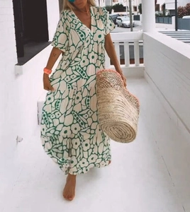 Detail of floral print maxi dress with deep V-neck and layered hem in summer setting