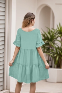 Back view of mint green V-neck dress featuring layered ruffle tiers and butterfly sleeves