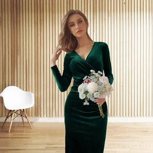 Detail of elegant dark green velvet dress featuring a wrap V-neckline and slim fit design