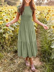 Detail of smocked elastic bodice and ruffled flutter sleeves on a green tiered maxi dress