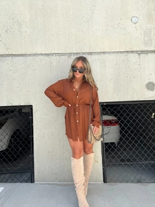 Brown long sleeve shirt dress featuring drawstring waist and button-down front detail