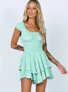 Detail of mint green swiss dot dress showing smocked waist and ruffled cap sleeves