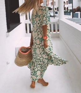 Detail of summer vacation long dress featuring green floral print and layered cake skirt style