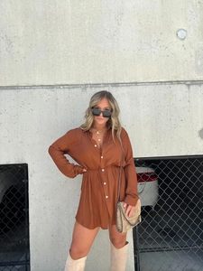 Detail of rust red shirt dress with long sleeves, button closure and drawstring waist