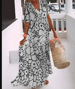 Macro shot of V-neck bohemian maxi dress with floral print and woven straw bag accessory