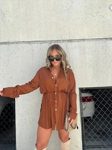 Detail of caramel satin long-sleeve shirt dress featuring drawstring waist and buttons