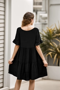 Back view of a black tiered summer dress with ruffle sleeves and multi-layer cake skirt