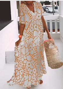 Detailed view of women's V-neck floral summer maxi dress with tiered skirt in a sunny setting
