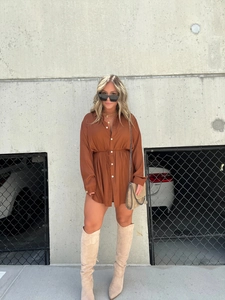 Outdoor shot of brown long sleeve shirt dress with drawstring waist and beige tall boots
