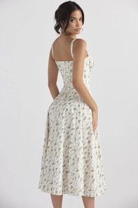 Detail of floral print pattern on a white summer maxi dress with green flowers