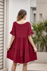Macro detail of the ruffled sleeves and layered hem on a wine red babydoll dress