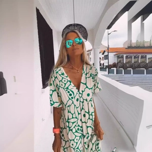 Elegant summer V-neck maxi dress with green floral print and long sleeves in white background