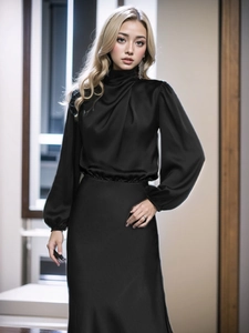 Dettaglio dell'elegante top in raso nero a maniche lunghe con collo alto e gonna lunga