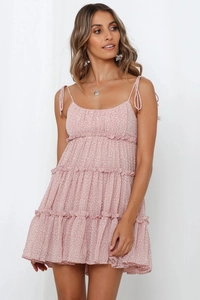Détail de la robe d'été rose pâle à fleurs avec fines bretelles et buste plissé