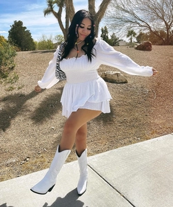 Detail of white long sleeve mini dress with smocked bodice and swiss dot fabric