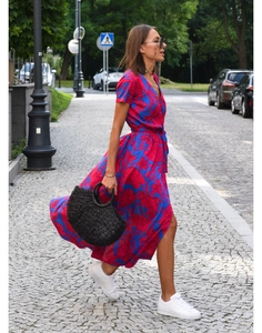 Close-up of bright blue V-neck midi dress with floral print and flowy hem in motion