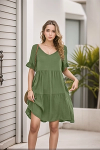 Close-up detail of green V-neck dress with layered ruffle skirt and lightweight texture