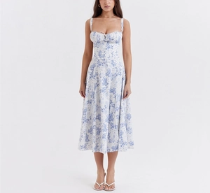 Detail view of a white floral sundress featuring thin straps and a side leg slit