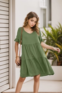 Detail of V-neckline and tiered ruffle layers on a summer grass green cotton dress