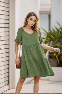 Detail of sage green V-neck mini dress with ruffled sleeves and tiered cake skirt texture