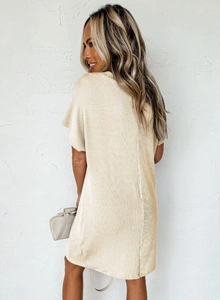 Detail of cream pleated short sleeve dress showing texture and side silhouette