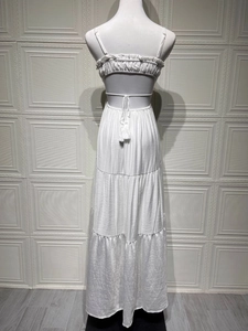 Detail of white tiered maxi dress with adjustable tie-back and tassel accents