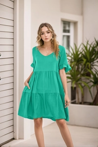 Detail of V-neck and ruffle sleeves on a vibrant green tiered summer babydoll dress