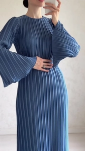 Detail of navy blue pleated long dress showing vertical texture and flared sleeves