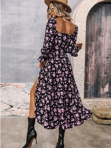 Detail of bohemian floral maxi dress featuring an open back and side split on black fabric