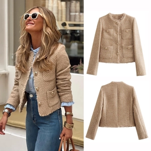 Close-up of beige tweed jacket featuring vintage gold buttons and frayed trim detail