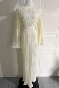 Detail of elegant pleated cream midi dress featuring flared sleeves and a pearl button