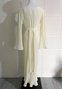 Detail of the cream pleated maxi dress showing flared sleeves and textured fabric
