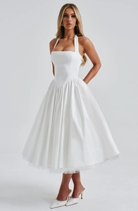 Full-body shot of white halter midi dress with a pleated skirt and voluminous hemline