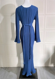 Detailed view of the dark blue pleated dress featuring flared sleeves and a belted waist