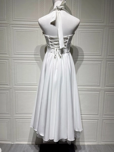 Detailed back view of a white halter dress featuring cross lace-up straps and elastic waist