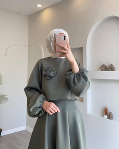 Detalle de la blusa verde musgo con mangas de linterna y flores de tela en conjunto musulmán