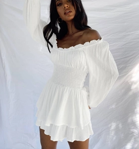 Detail of white Swiss dot fabric on an off-shoulder romper dress with ruffles