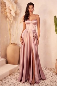 Detail of satin evening gown featuring corset bodice and high slit in dusty pink