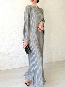 Detail of light grey pleated maxi dress with elegant trumpet sleeves and flowing texture