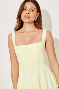 Détail de l'encolure carrée et coutures verticales sur la robe mi-longue jaune pâle ajustée