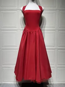 Detailed view of red satin ballgown dress with halter neck and layered tulle hem