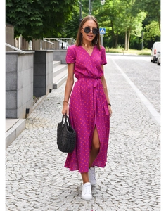 Detail view of purple V-neck dress with red polka dot print and side slit design