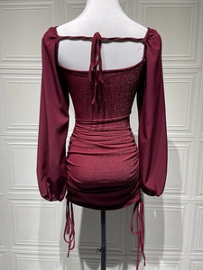 Detail of burgundy sequin dress featuring back lace-up design and pleated bodycon fit