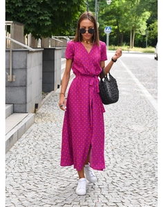 Close-up of a purple V-neck dress with orange polka dots and a stylish waist tie