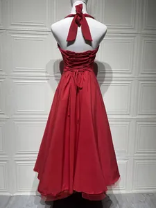 Detail of red halter dress back featuring elegant bow tie and corset lacing design