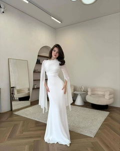 Detail of elegant white long sleeve dress with slit cape sleeves and ruched bodice design