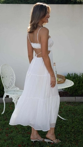 Detail of white backless tiered maxi dress with lace-up straps and tiered skirt