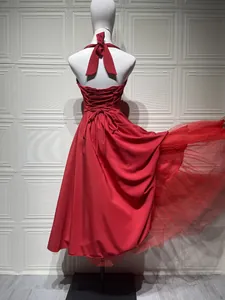 Detailed back view of a red lace-up evening dress with tiered tulle and halter neck bow