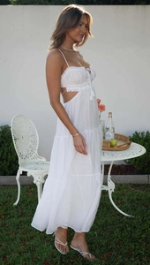 Detail of white maxi dress with ruffled bodice, side cutouts, and tiered skirt layers