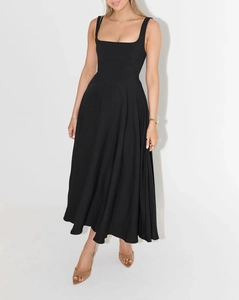 Détail d'une robe midi noire à col carré avec larges bretelles et jupe évasée plissée